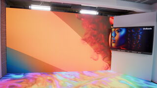 Bunte LED-Displays wurden in dem neuen Studio des LMZ installiert. Die Displays zeigen Farben im Orangenfarbraum. Eine Fotografie einer Frau vervollständigt sich durch die Darstellung auf LED-Wänden und TV-Bildschirm.